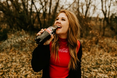 The woman drink Coca Cola bottle
